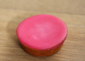 mini pink fondant cakes on wooden background
