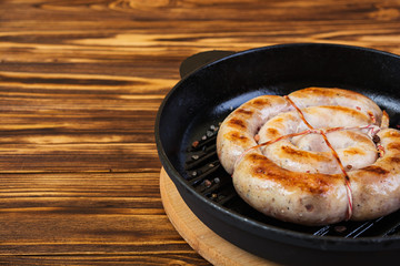 Grilled homemade sausage on wooden background