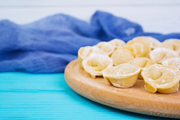 Homemade raw dumplings, pelmeni, on wooden background.