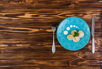 Delicious homemade dumplings, pelmeni, on wooden background