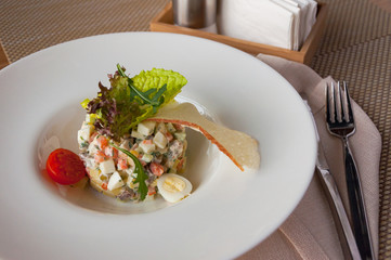 Traditional Russian salad Olivier on white plate