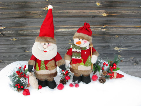 christmas santa snowman decoration winter berries and snow on wooden background