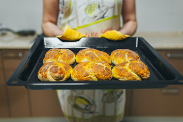 Woman put batter for cupcakes in oven in kitchen closeup. Cooking time.