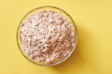 Cup of oatmeal. Delicious healthy breakfast. Yellow background