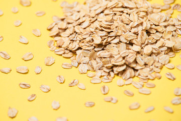 Many of oat flakes. Healthy eating. Yellow background