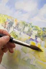 Close up hand of artist painting water colour landscape