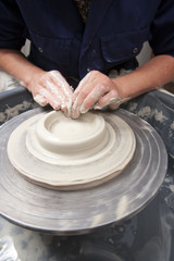 A lady ceramics artist at work in her home pottery studio, opening up