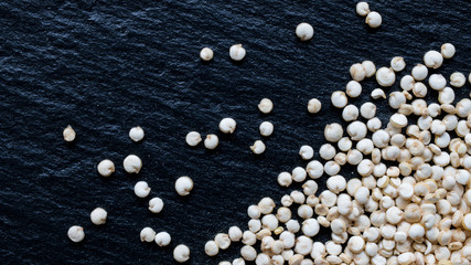 Quinoa seeds on black slate background, macro, top view