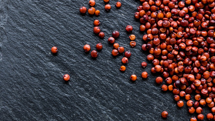 Quinoa seeds on black slate background, macro, top view