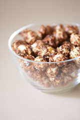 Caramel pop corn. Glass plate. Light background