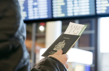 Man with a Canadian passport and boarding pass looks departure - 194134879