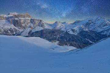 Fantastic starry sky. Panoramic view of the Val Di Fassa ski resort of the Italian Dolomites under starry light
