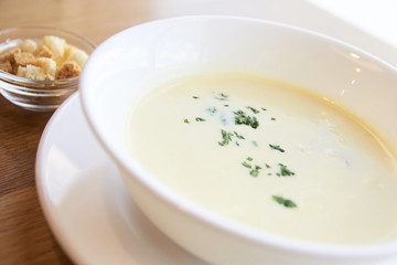 Delicious cheese soup. White dishes. Small crackers