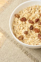 Delicious healthy breakfast. Neutral background. Oatmeal with raisins