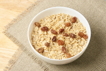 Delicious healthy breakfast. Neutral background. Oatmeal with raisins