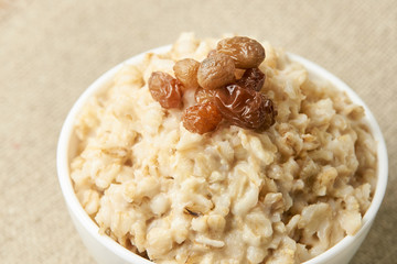 Delicious healthy breakfast. Oatmeal with raisins. Neutral background