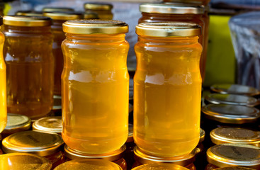 Glass jar of honey set with lid closeup