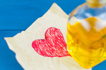 The red heart is painted on paper. On it there is an elixir in a small bottle.