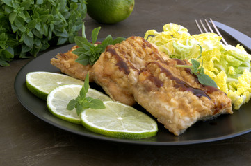 Fried fish with salad on a gray plate.