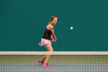 femme jouant au tennis dans un gymnase