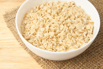 Oatmeal porridge. White bowl. Light background. Healthy food