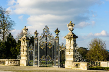 The majestic main entrance gate of the Noisiel public park, in the eastern suburbs of Paris, is made of a richly decorated wrought iron grid between two carved stone pillars.