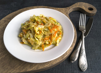 cabbage braised in white plate on black background