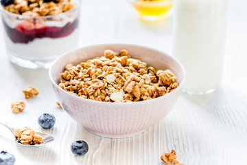 Fitness breakfast with muesli, honey and milk on white table