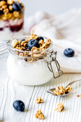Homemade fitness granola with yoghurt and berries on white kitch