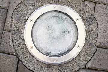 Round lantern on the ground. Gray asphalt