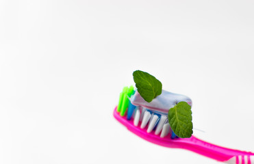 Toothbrush with toothpaste and mint on a white background.