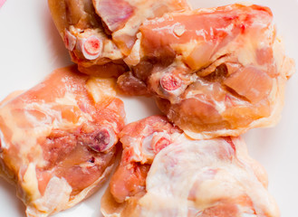 Raw chicken thighs on a white plate.