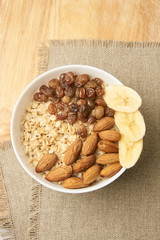 White cup. Oatmeal with raisins banana and almonds
