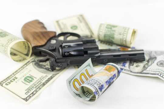 Pistol and money on a white background. The concept of crime is because of money.