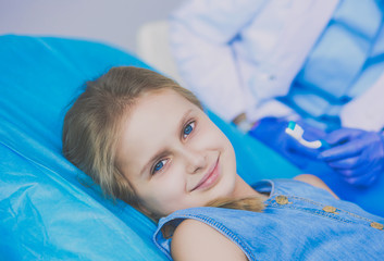 Obraz na płótnie Canvas Little girl sitting in the dentists office