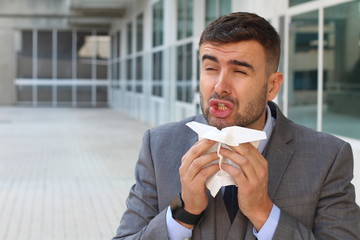 Businessman sneezing in office space