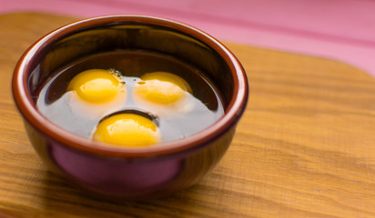 Raw chicken eggs in a plate .