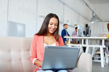 happy woman with laptop working at office