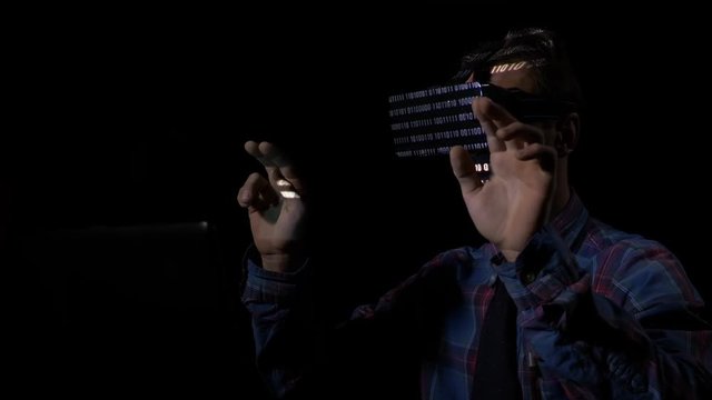 Dangerous hacker using virtual reality vr glasses and holograms in his hideout to break into government system and steal the data