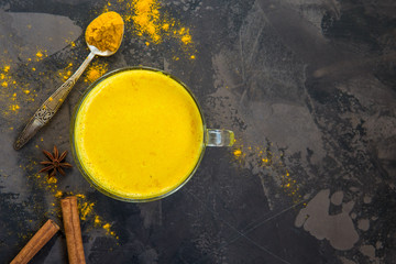 Obraz na płótnie Canvas Golden turmeric milk with cinnamon. Healthy and aromatic detox beverage