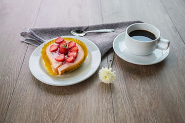 Cake and strawberries on wood background.