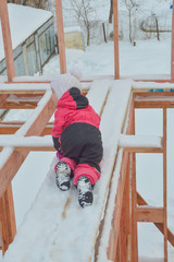 a girl is dangerous to climb on the construction of a frame house in the winter, a brave child