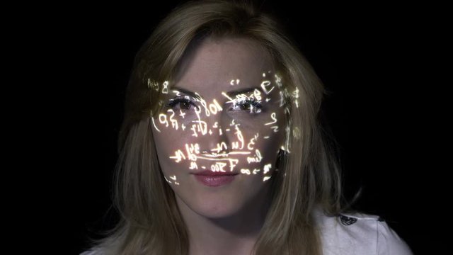 Portrait of a smart intelligent blonde woman thinking how to solve integrals while math formulas are projected on her face