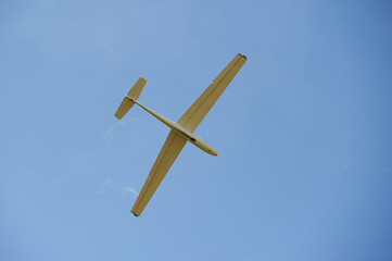 A Glider flying in bleu sky. The glider is a plane that has no engine
