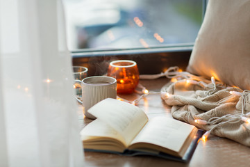 Obraz premium book and coffee or hot chocolate on window sill