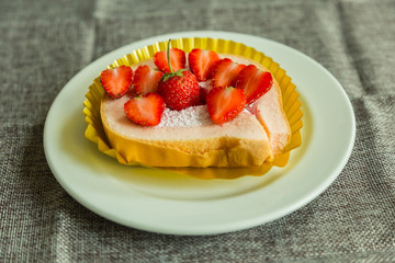 Cake and strawberries on wood background.
