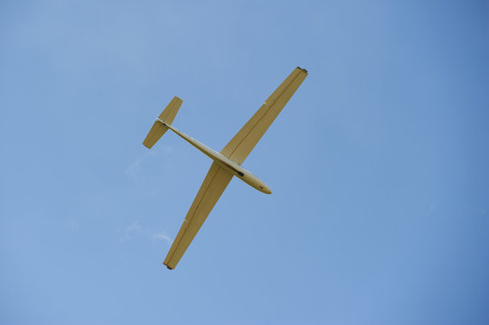A Glider flying in bleu sky. The glider is a plane that has no engine
