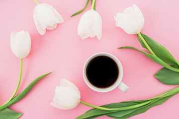 White tulips with mug of coffee on pink background. Blogger concept. Flat lay, top view.