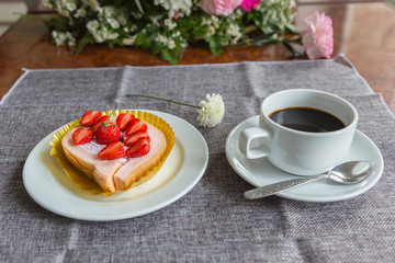 Cake and strawberries on wood background.