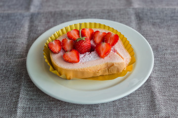 Cake and strawberries on wood background.